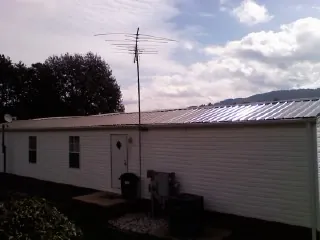 New metal roof on a single wide mobile home with a TV antenna in Carver