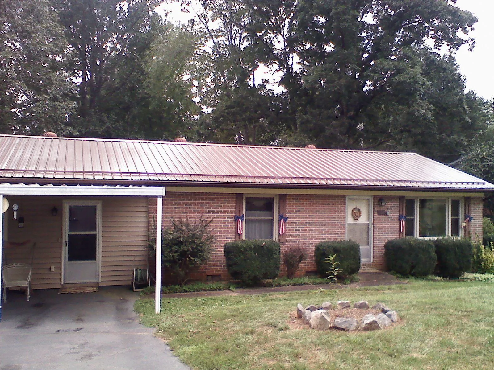 Bronze metal roof and carport on a brick ranch home — Roof Repair work by our crew in Carver